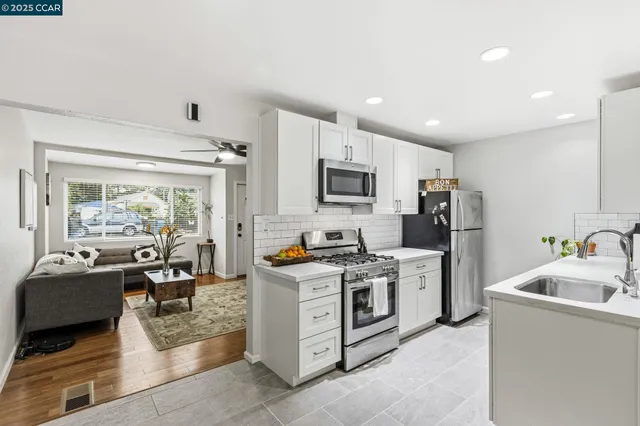 a view of kitchen with microwave a stove and furniture