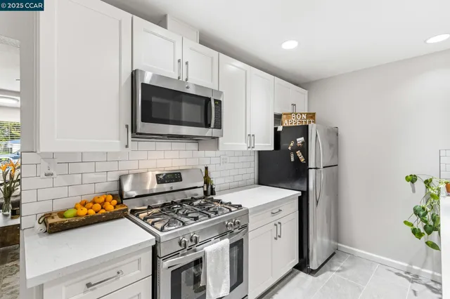 a kitchen with stainless steel appliances a stove microwave and refrigerator