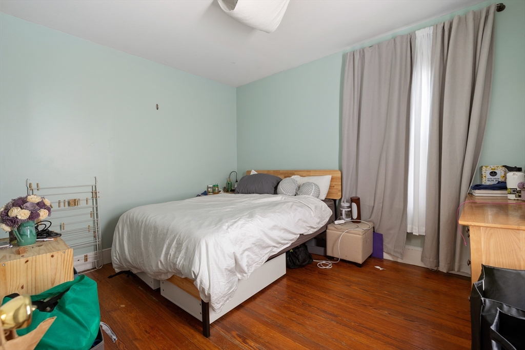 14-16 Holyoke Road Somerville, MA 02144 - Photo 18 of 34 a bedroom with a bed and wooden floor