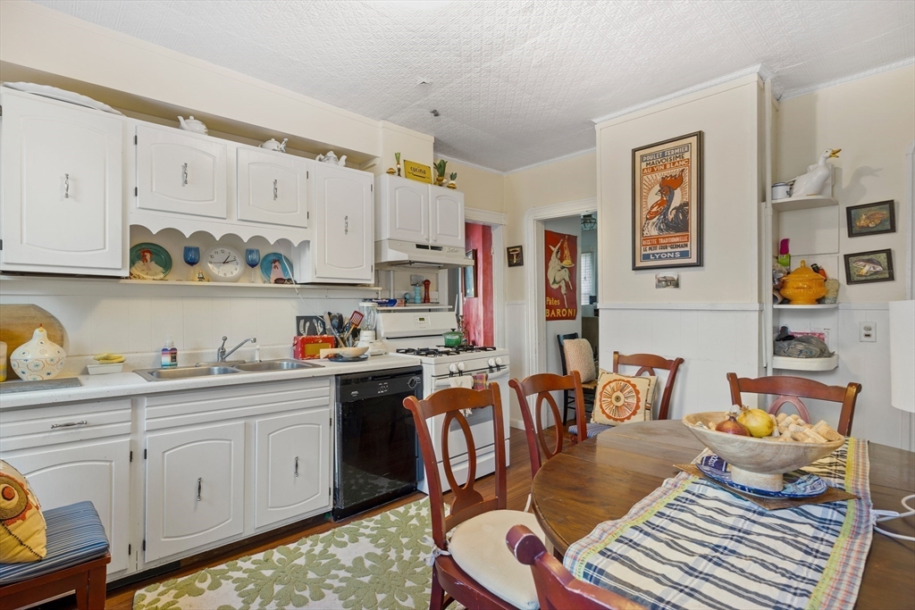 14-16 Holyoke Road Somerville, MA 02144 - Photo 23 of 34 a kitchen with stainless steel appliances granite countertop a stove a sink dishwasher and cabinets with wooden floor