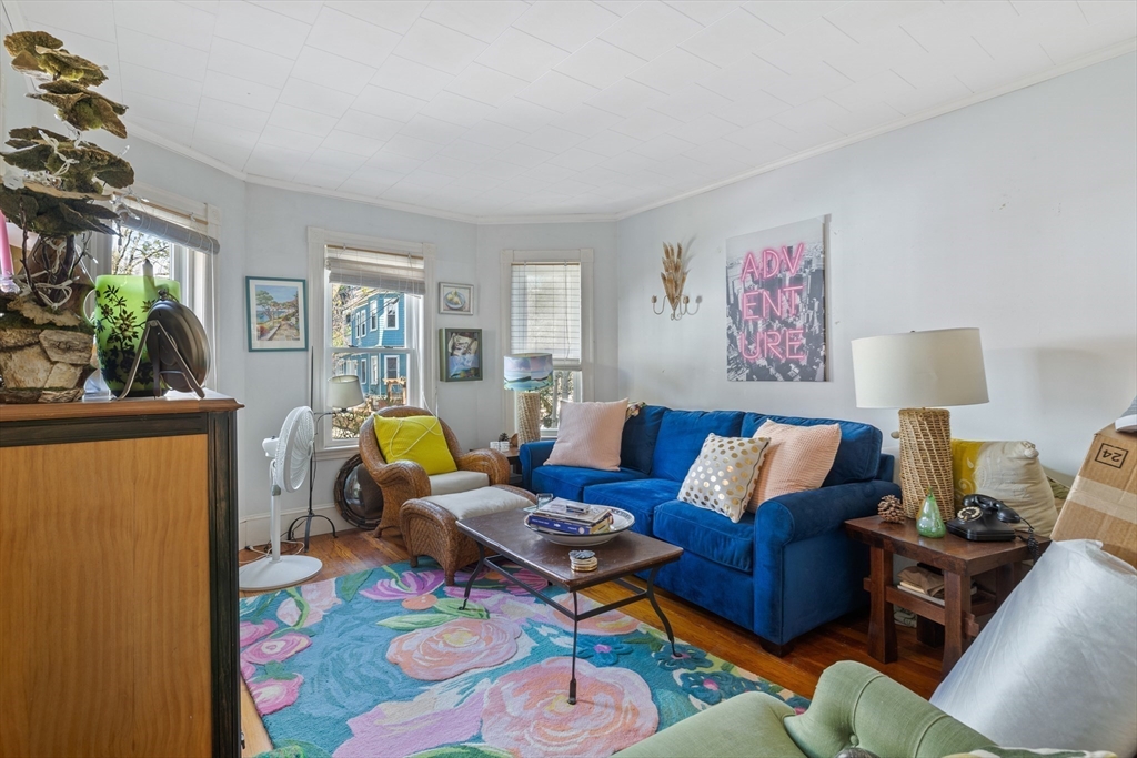 14-16 Holyoke Road Somerville, MA 02144 - Photo 24 of 34 a living room with furniture a couch and a bookshelf with wooden floor