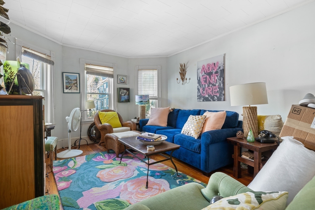 14-16 Holyoke Road Somerville, MA 02144 - Photo 25 of 34 a living room with furniture a lamp wooden floor and a window