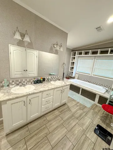 a large white kitchen with a sink and cabinets