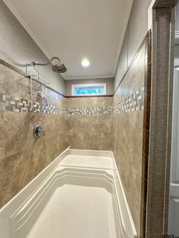 a bathroom with a bathtub and shower