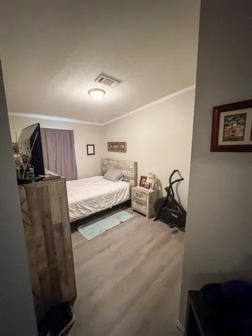 a bedroom with a bed a couch and a view of kitchen