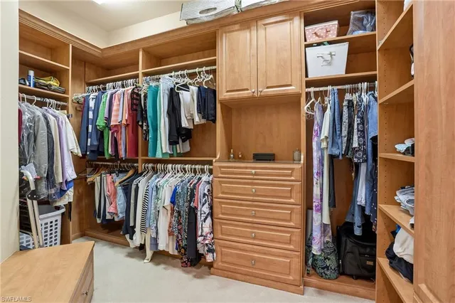 a view of walk in closet with clothes and shoes