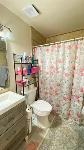 a bathroom with a toilet sink and shower curtain