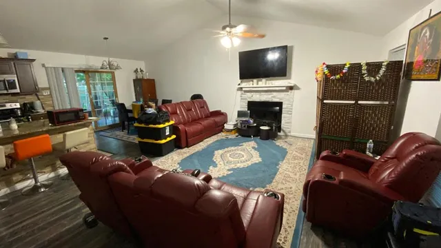 a living room with furniture a flat screen tv and a fireplace