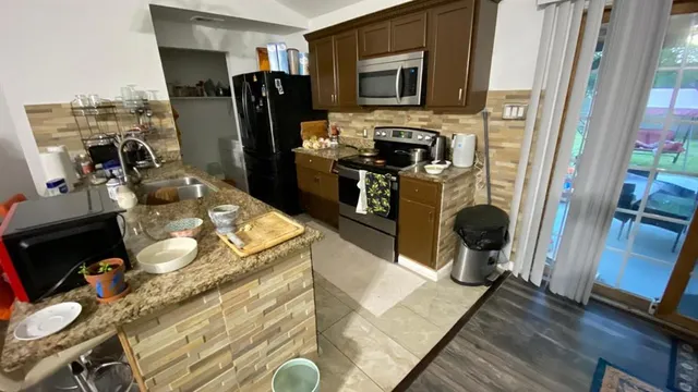 a kitchen with sink refrigerator and stove