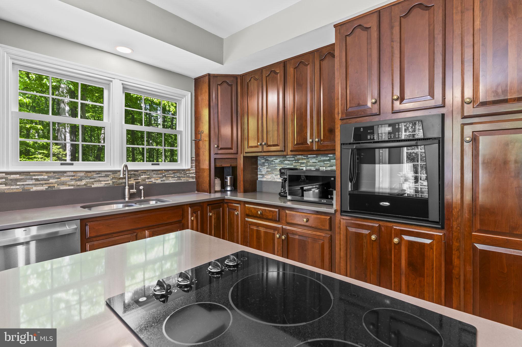 4111 Buck Board Lane Dunkirk, MD 20754 - Photo 22 of 74 a kitchen with granite countertop wooden cabinets a sink and a stove