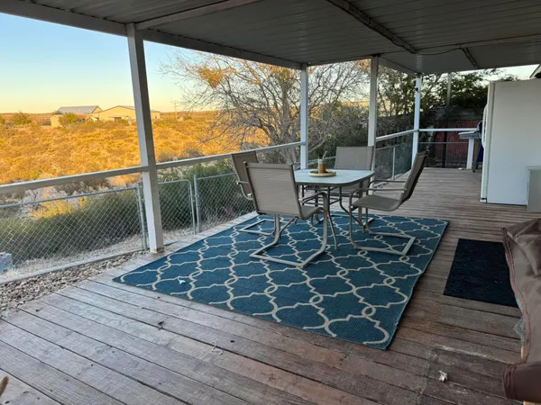 a view of a roof deck with table and chairs and wooden floor