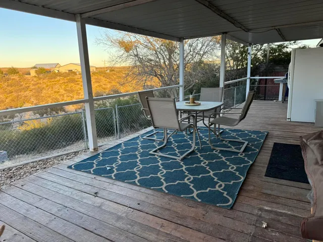 a view of a roof deck with table and chairs and wooden floor