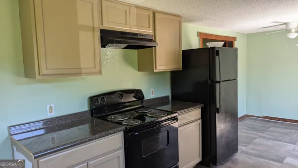 a kitchen with stainless steel appliances granite countertop a refrigerator and a stove