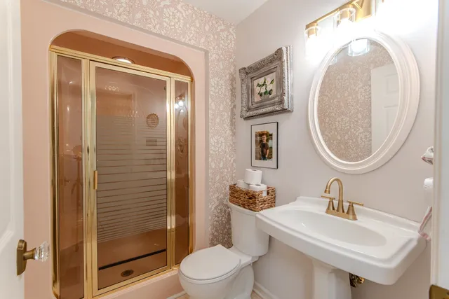 a bathroom with a sink a toilet and a mirror