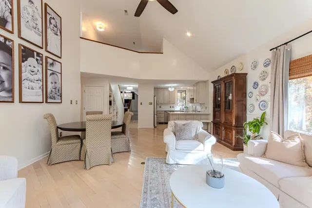 a living room with furniture kitchen view and a large window