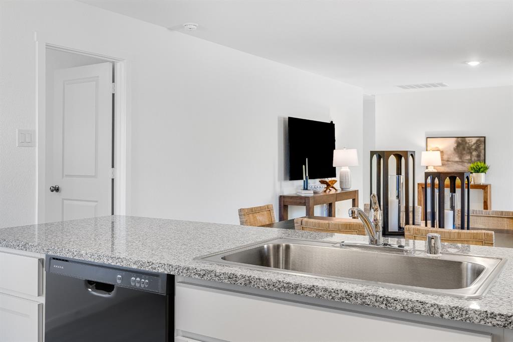 1263 Maple Street Wilmer, TX 75172 - Photo 10 of 22 a kitchen with granite countertop a sink and a large mirror next to a window