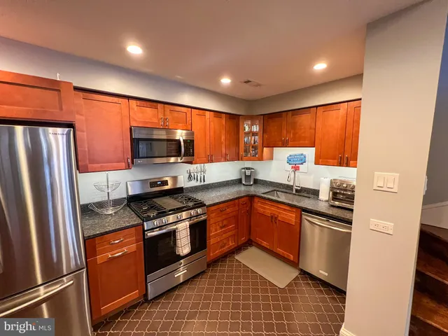a kitchen with stainless steel appliances granite countertop a refrigerator stove microwave and sink