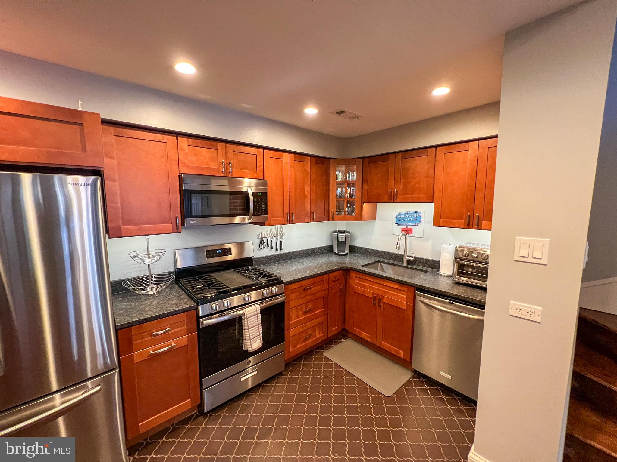 604 South 12th Street Philadelphia, PA 19147 - Photo 4 of 14 a kitchen with stainless steel appliances granite countertop a refrigerator stove microwave and sink