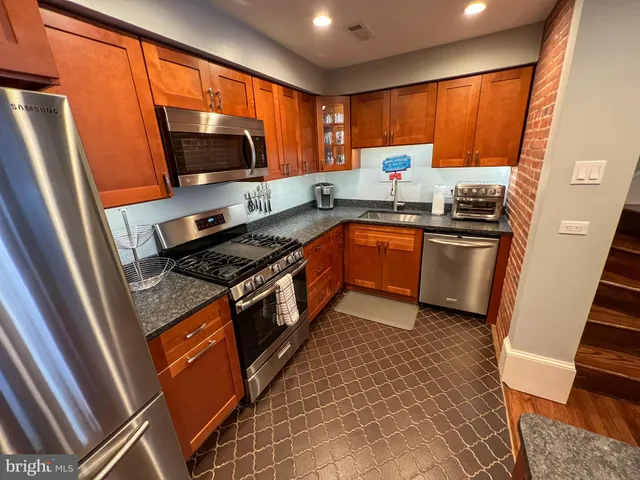 a kitchen with stainless steel appliances granite countertop a refrigerator stove microwave and sink