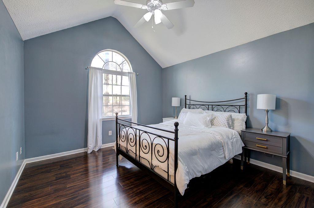 205 Cryder Lane Canton, GA 30115 - Photo 22 of 38 a bed sitting in a bedroom next to a window with a chandelier