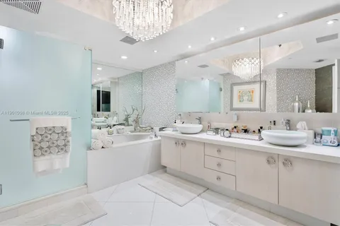 a spacious bathroom with a double vanity sink mirror and bathtub