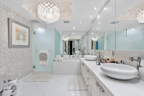 a bathroom with a double vanity sink mirror and bathtub