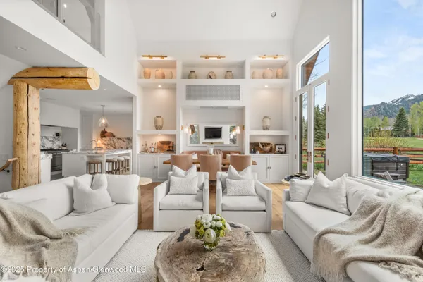 a view of a living room filled with furniture and a floor to ceiling window