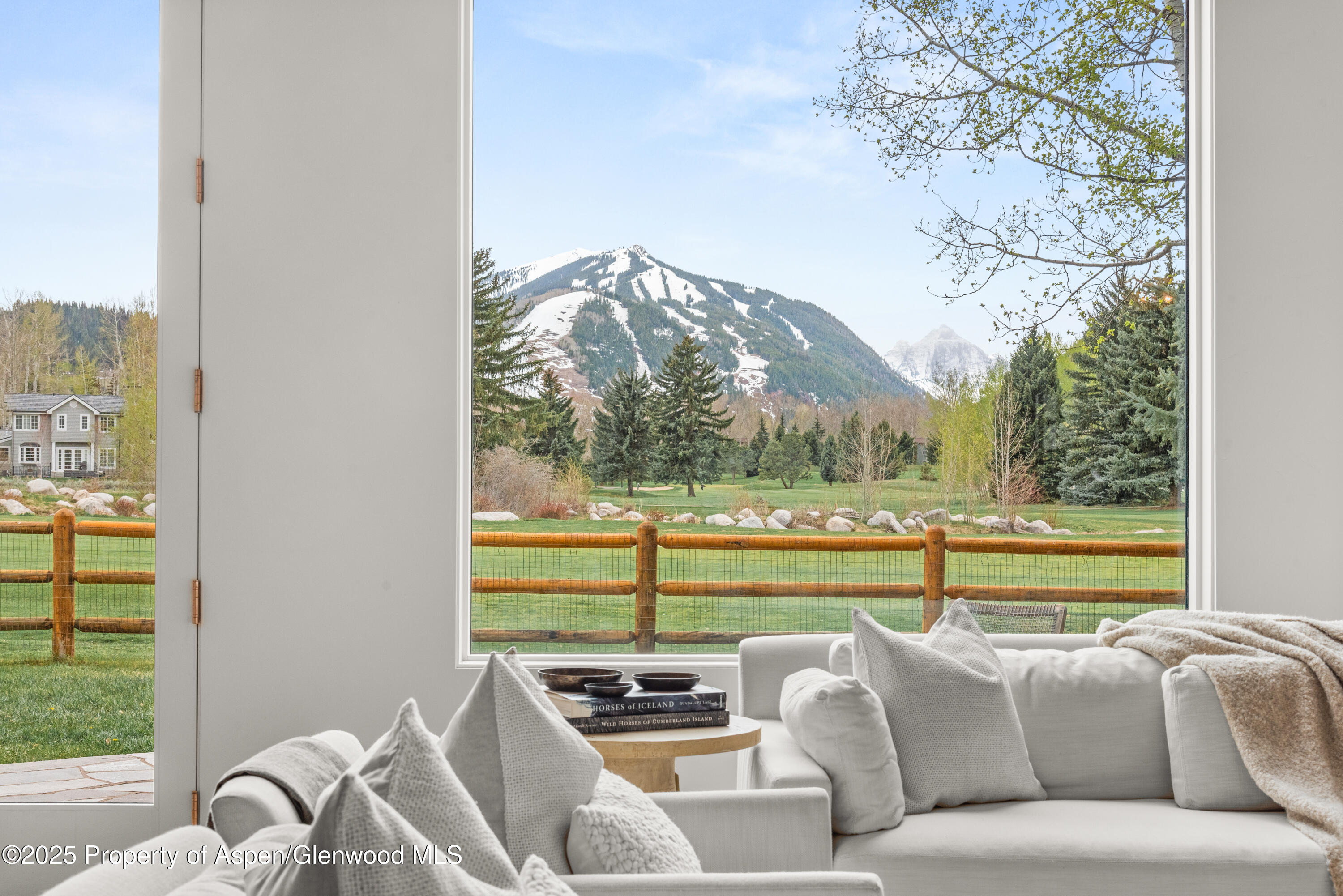 1495 Homestake Drive, Unit 2 Aspen, CO 81611 - Photo 20 of 42 a view of a living room filled with furniture and a floor to ceiling window