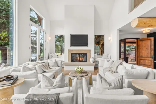 a living room with fireplace furniture and a large window