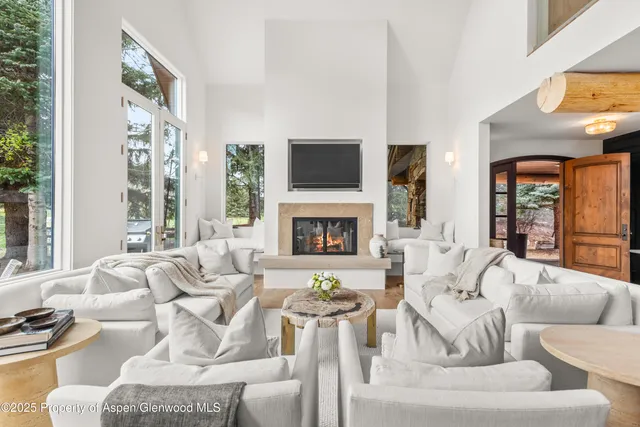 a living room with fireplace furniture and a large window