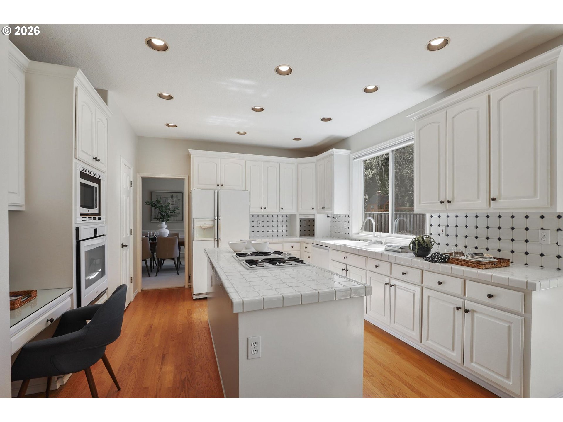 17650 Northwest Gilbert Lane Portland, OR 97229 - Photo 6 of 26 a kitchen with granite countertop a sink stove refrigerator and white cabinets with wooden floor