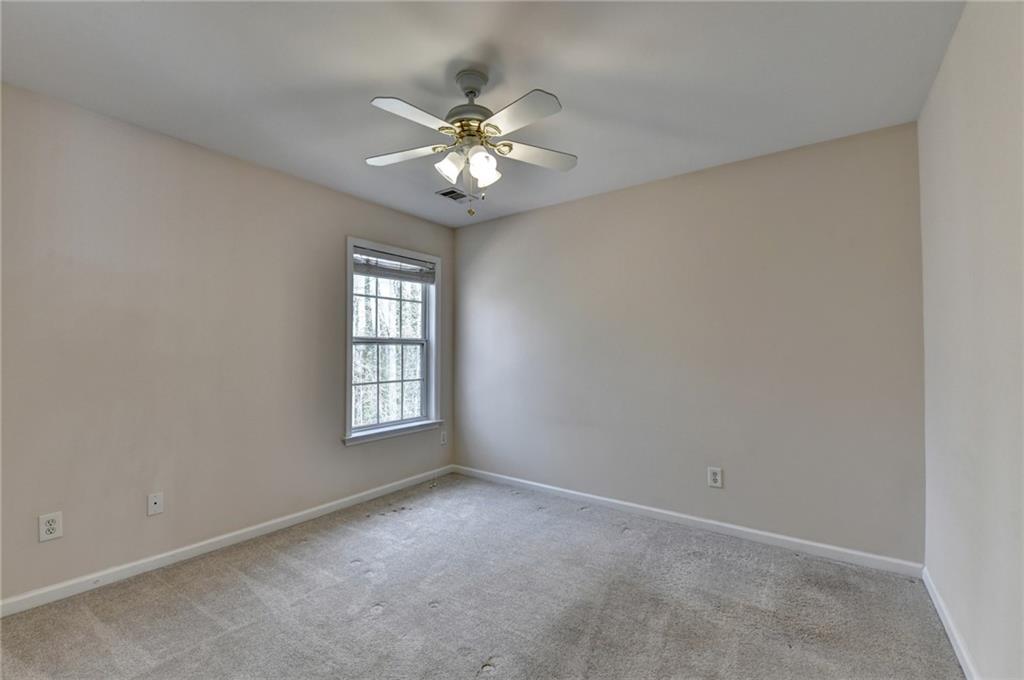 100 Hawnley Trc Northwest Suwanee, GA 30024 - Photo 49 of 58 an empty room with windows and chandelier fan