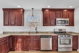 194 Leslie Road Rowley, MA 01969 - Photo 3 of 34 a kitchen with stainless steel appliances granite countertop a stove a microwave and wooden cabinets
