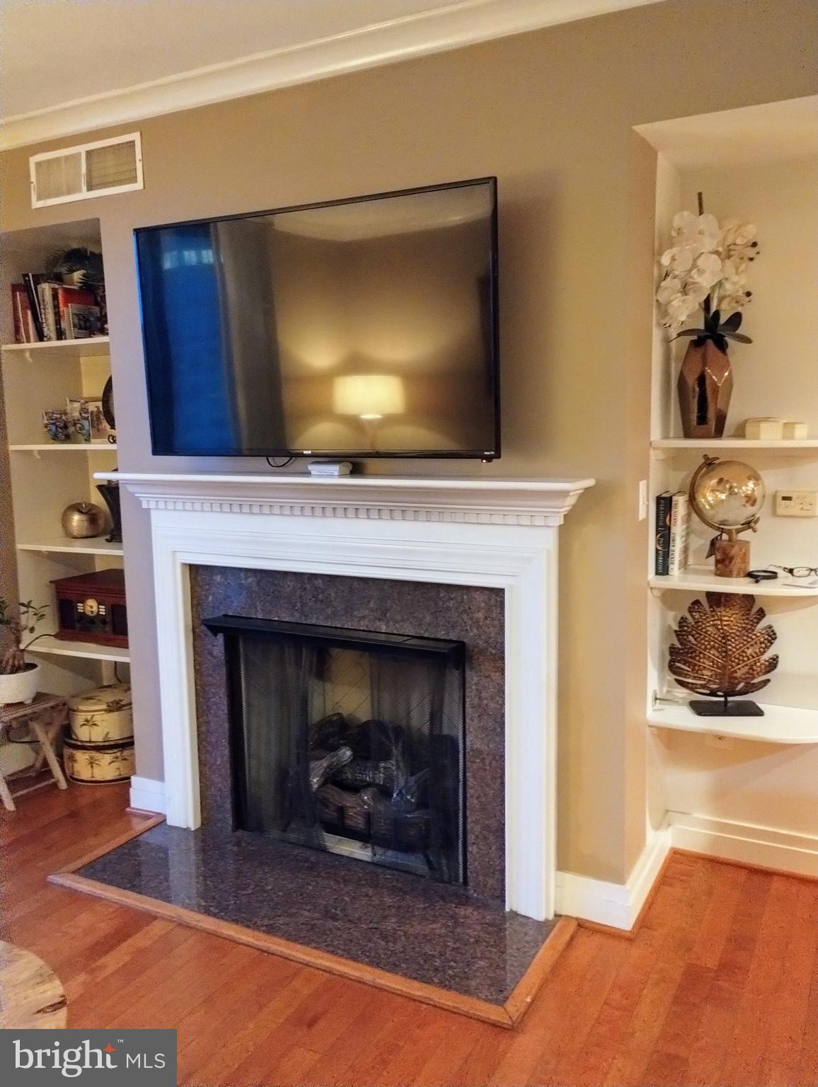 414 Water Street, Unit 1608 Baltimore, MD 21202 - Photo 15 of 26 a living room with a fireplace and a flat screen tv