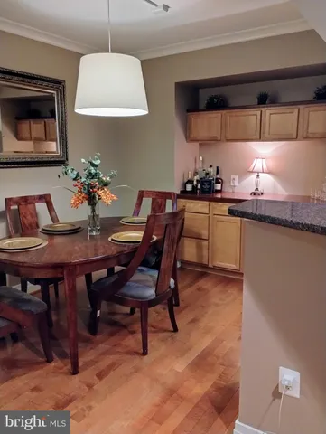 a kitchen with stainless steel appliances a dining table chairs and sink