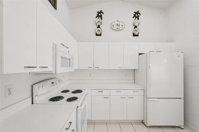 a kitchen with white cabinets and white appliances