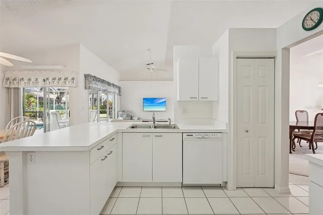 a kitchen with white cabinets appliances and a sink