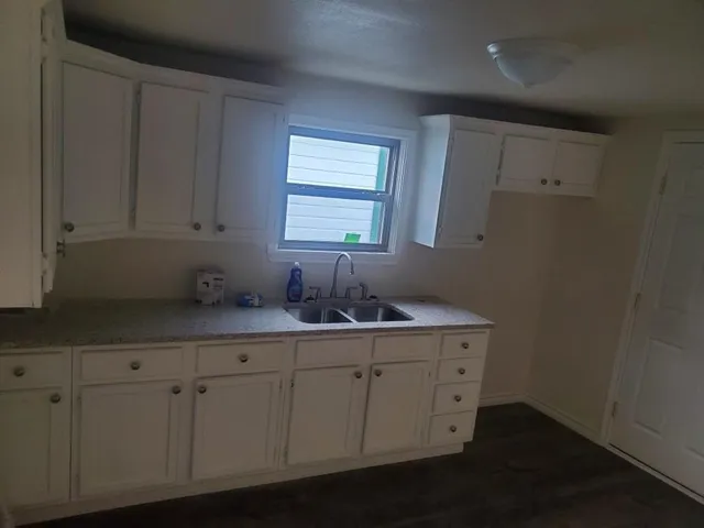 a room with a sink cabinets and a window
