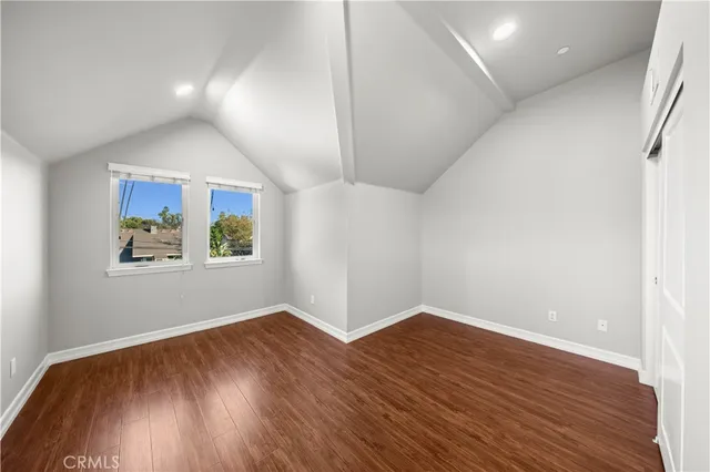 an empty room with wooden floor and window