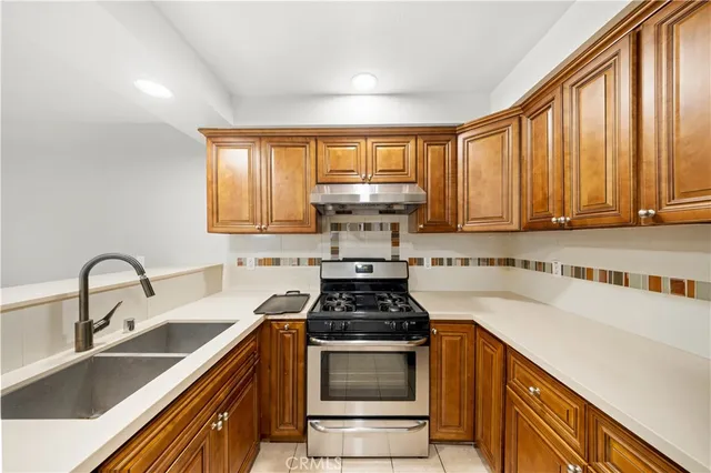 a kitchen with a sink stove top oven and cabinets