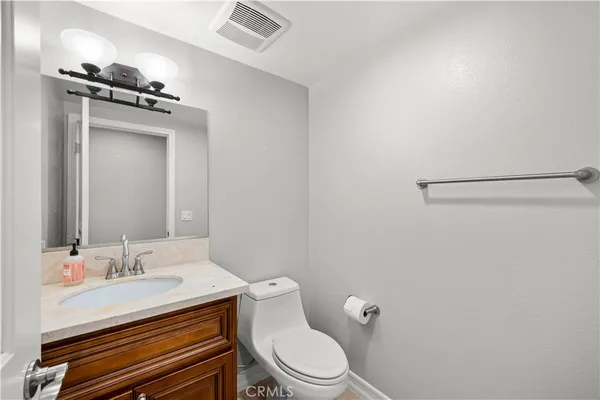 a bathroom with a granite countertop sink mirror vanity and toilet