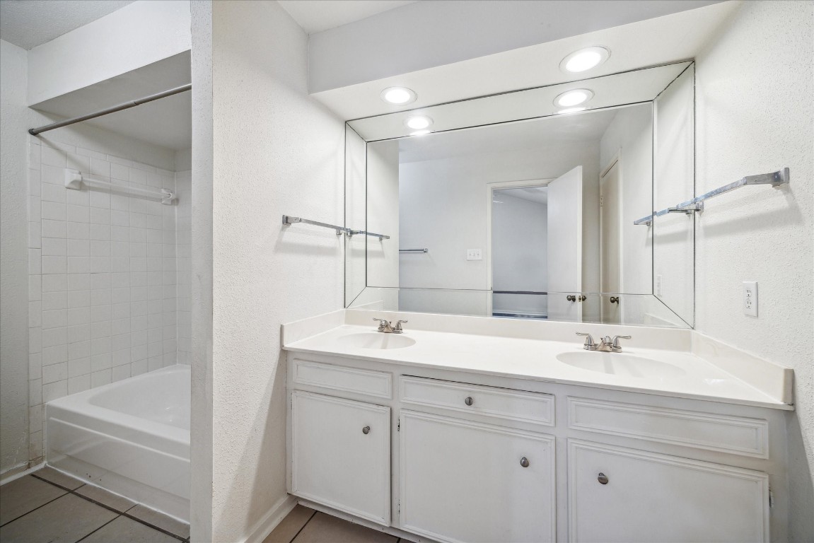 1864 South Gessner Road Houston, TX 77063 - Photo 12 of 17 a bathroom with a double vanity sink a mirror and a bathtub