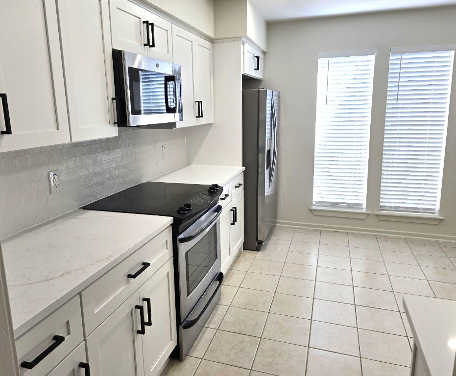 1864 South Gessner Road Houston, TX 77063 - Photo 8 of 17 a kitchen with a stove cabinets and a refrigerator
