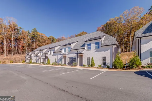 a kitchen with stainless steel appliances granite countertop a sink a stove a kitchen island with chairs and wooden floor