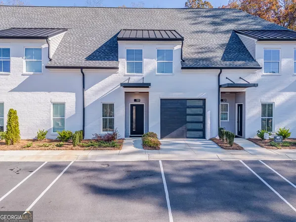 a front view of a house with garage and plants