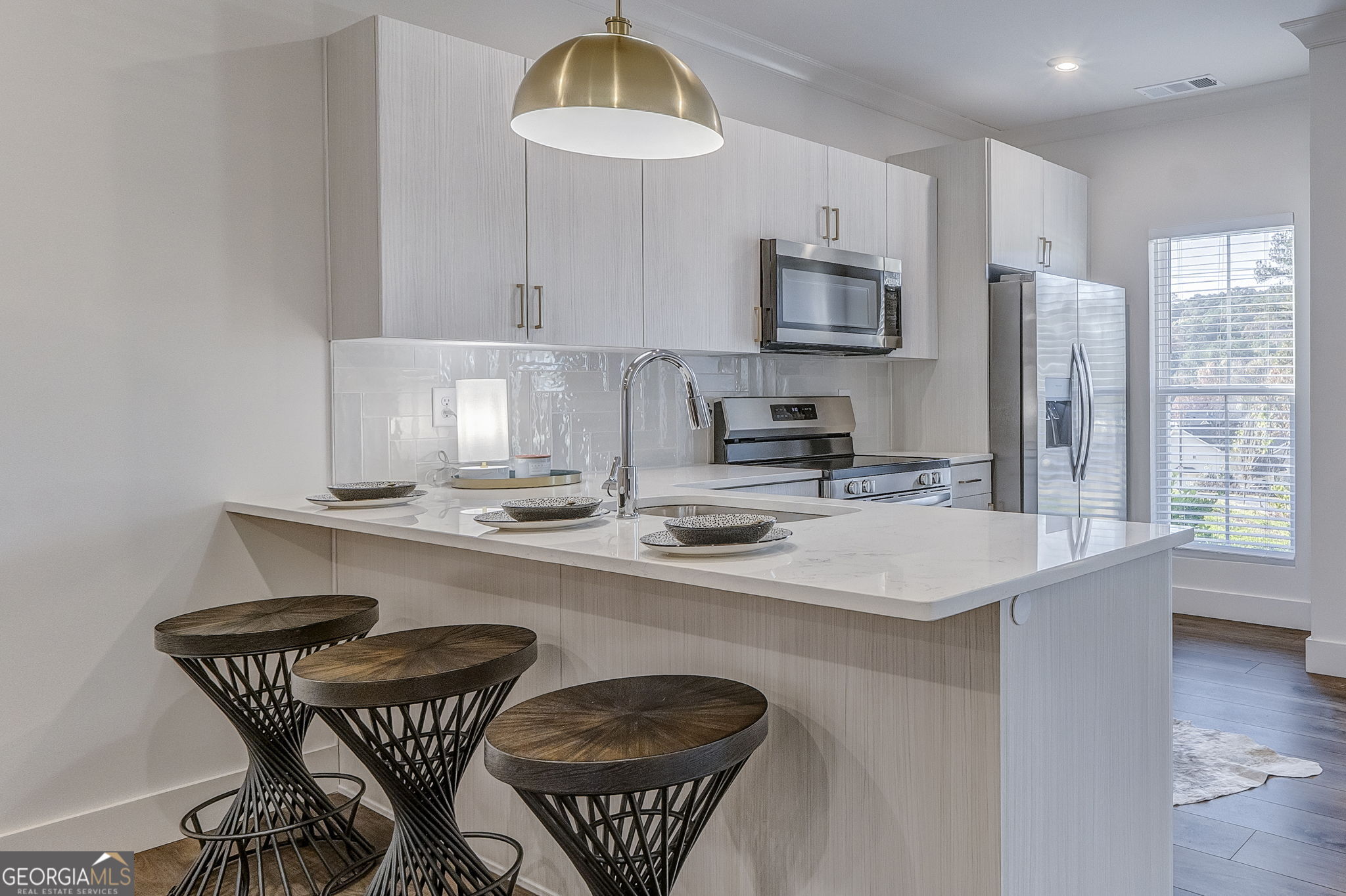 93 Chateau Drive Southeast Rome, GA 30161 - Photo 30 of 66 a kitchen with stainless steel appliances granite countertop a sink a stove a kitchen island with chairs and wooden floor