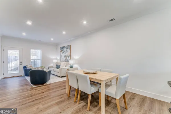 an empty room with wooden floor chandelier fan and windows