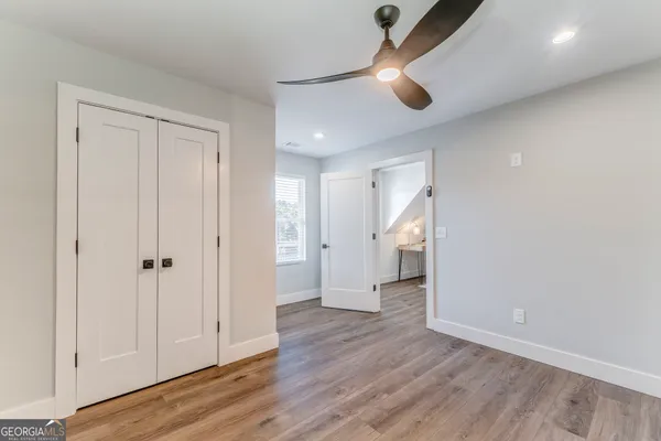 a bedroom with a bed and wooden floor