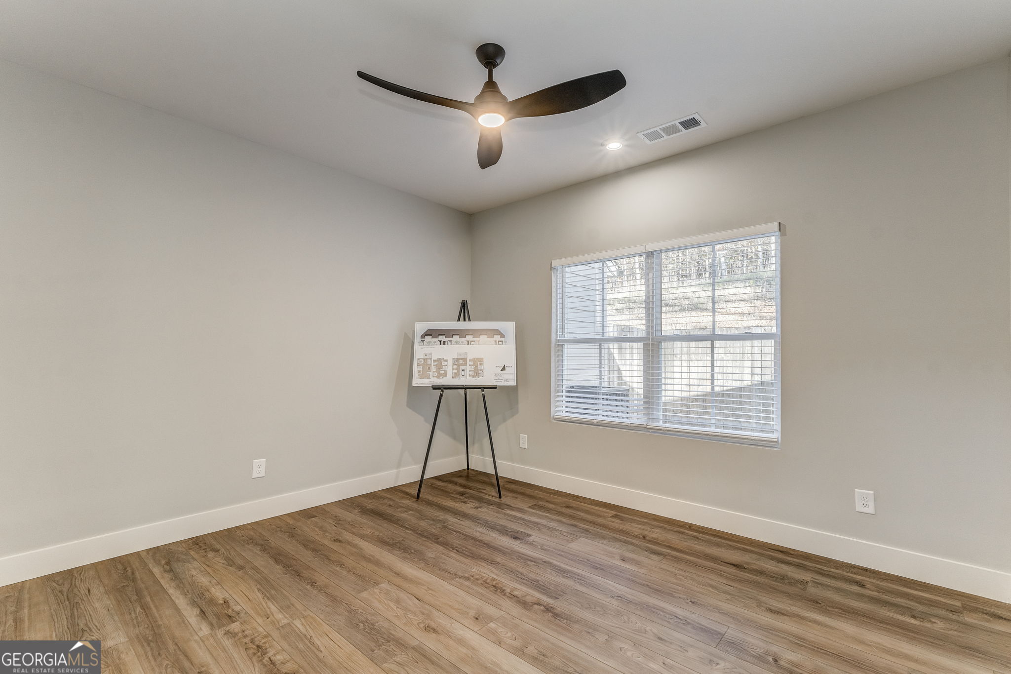 93 Chateau Drive Southeast Rome, GA 30161 - Photo 44 of 66 an empty room with wooden floor chandelier fan and windows
