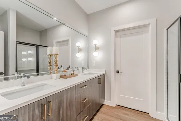 a bathroom with a granite countertop bathtub shower sink vanity mirror and toilet